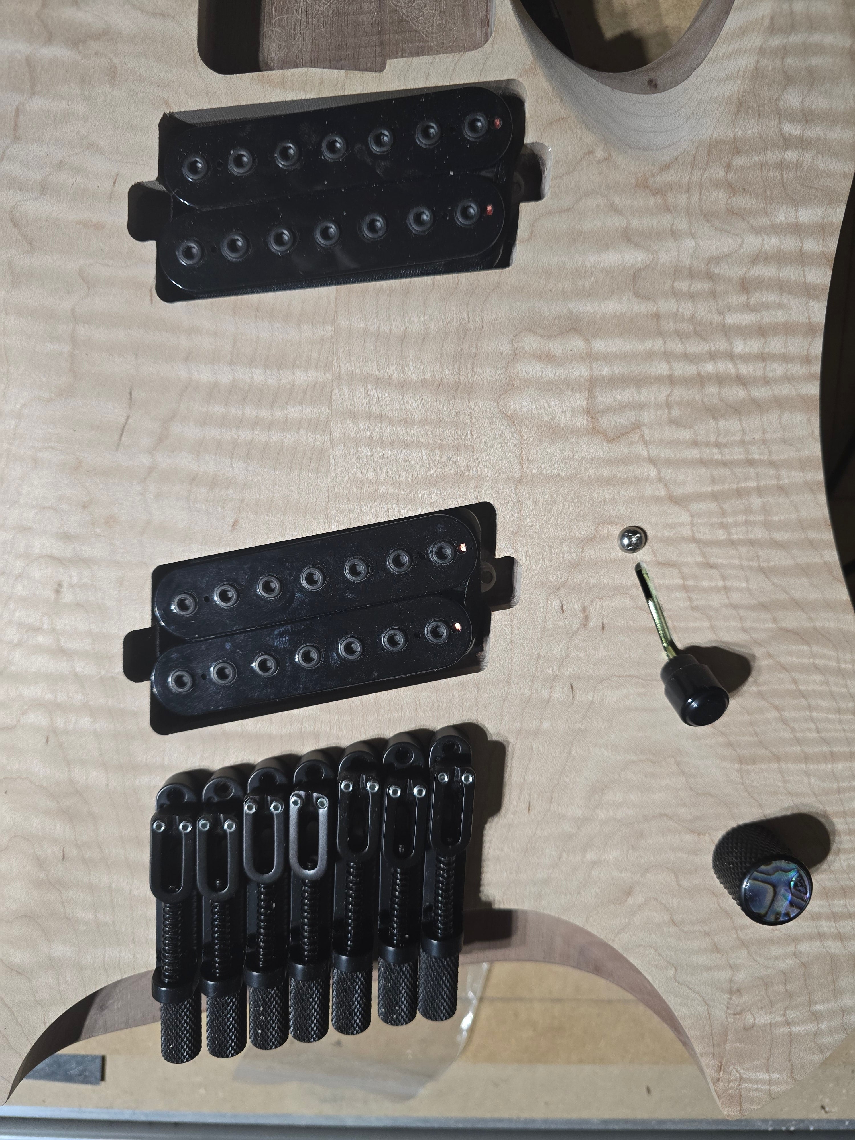 Guitar parts including pickups and knobs on a guitar body
